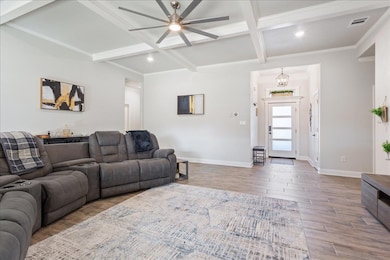Living area featuring ceiling fan, coffered ceili