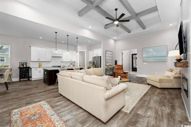 Living area with coffered ceiling, recessed lighting, dark wood-style floors, a ceiling fan, and beamed ceiling