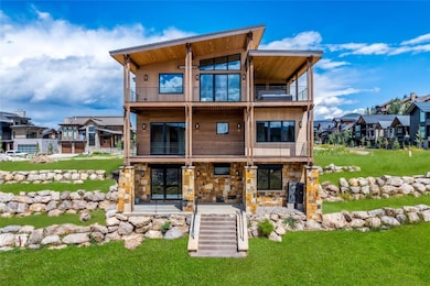 Rear view of house featuring a balcony, a yard, an