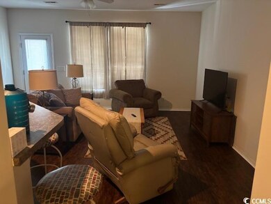 Living room with dark wood finished floors and ceiling fan