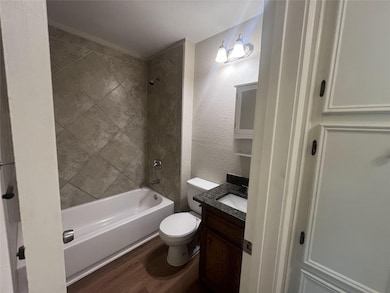 Bathroom featuring wood finished floors, toilet, 