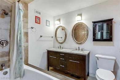 Full bathroom with toilet, double vanity, visible