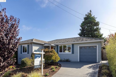 Ranch-style home featuring a tiled roof, driveway, and a garage