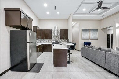 Kitchen featuring appliances with stainless steel finishes, open floor plan, a breakfast bar, and light countertops