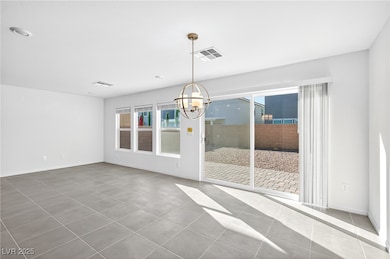 Unfurnished dining area with a chandelier and tile patterned flooring