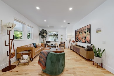 Living room with recessed lighting and light wood