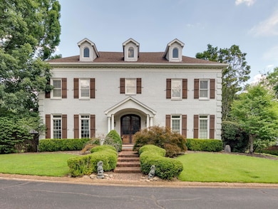 Colonial house featuring french doors, brick siding, and a front yard