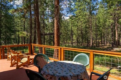 The generous deck overlooks the surrounding forest and stream.