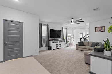 Living area featuring light carpet, stairway, and