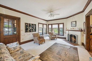 Living room featuring a fireplace, ceiling fan, cr