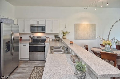 Kitchen featuring white cabinets, stainless steel
