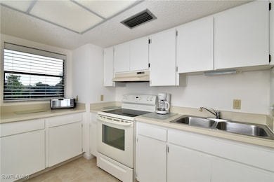 Kitchen with a textured ceiling, white range with