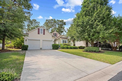 Traditional-style house featuring driveway, a front lawn, and an attached garage