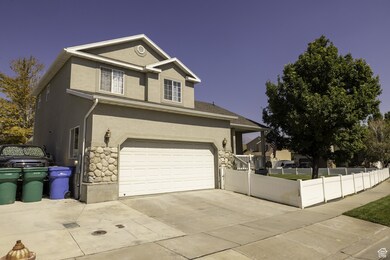 Traditional-style house featuring driveway, stucco siding, stone siding, and a garage