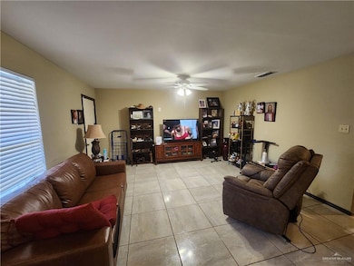 Living room with ceiling fan and light tile patterned floors