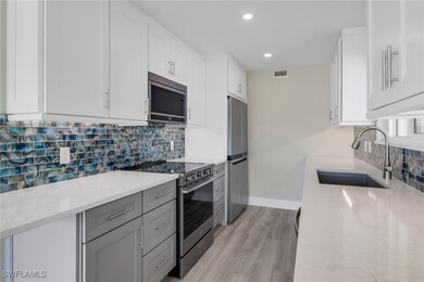 Kitchen with white cabinets, tasteful backsplash, stainless steel appliances, and recessed lighting