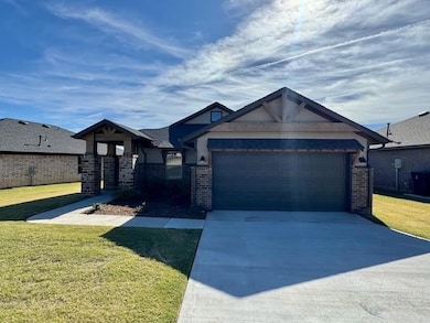 Craftsman house with a front yard, brick siding, driveway, and a garage