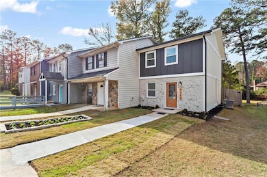 Townhome / multi-family property featuring central AC and a front lawn