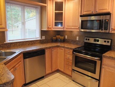 Remodeled kitchen with glass tile backsplash.