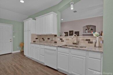 Kitchen featuring white dishwasher, light hardwood