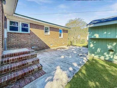 Rear view of property with crawl space, a patio, brick siding, and a yard