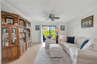 Living room featuring crown molding, light wood-ty