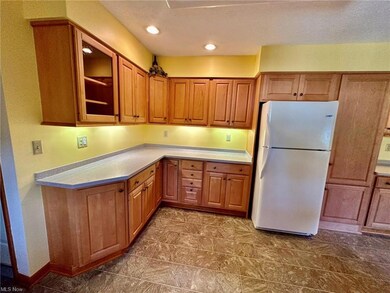 Kitchen with tile flooring, white fridge, light co