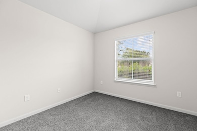 Empty room with dark carpet, baseboards, and vaul