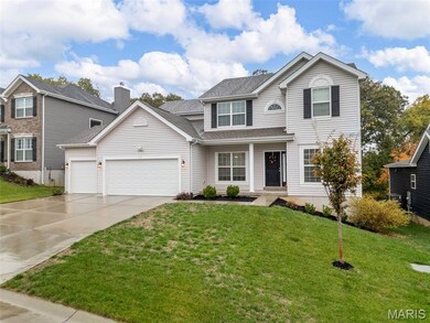 Traditional-style house with driveway, a porch, a front yard, and a garage