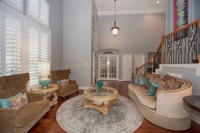 One of the many  bonuses in the home is the formal living room AND a study, which is entered through the paned French doors.  Note the high ceilings and windows with Plantation shutters.