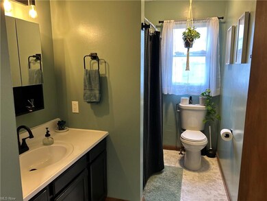 Bathroom with vanity, mirror, and light tile floor