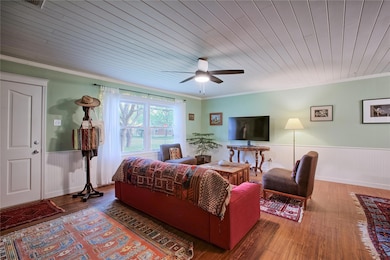 Living room featuring a wainscoted wall, ceiling 