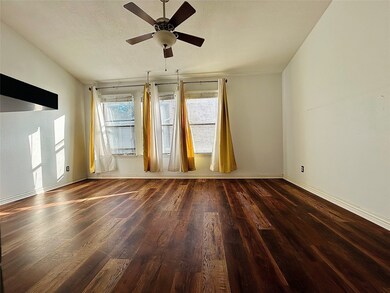 Empty room with dark wood finished floors, a textured ceiling, and ceiling fan
