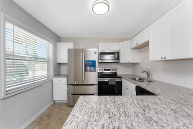 The renovated kitchen features stainless steel appliances, new cabinetry, and granite countertops.