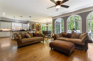 Living area featuring wood finished floors, ceiling fan, thick molding, a ceiling fan, and recessed lighting
