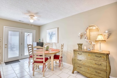 Tiled dining room featuring ceiling fan and a text