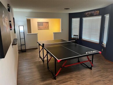 Game room with a textured ceiling and dark wood-ty