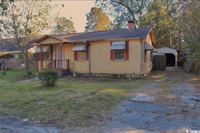 View of front facade with a chimney and a lawn