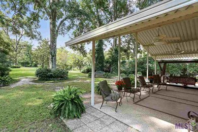 Spacious covered patio overlooking park like yard.