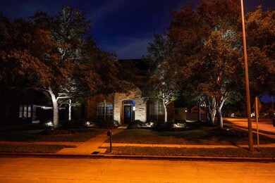 Night view of the front of the home with the up lighting in the garden.