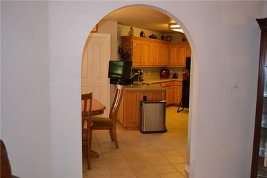 View of kitchen from family through arched doorway.