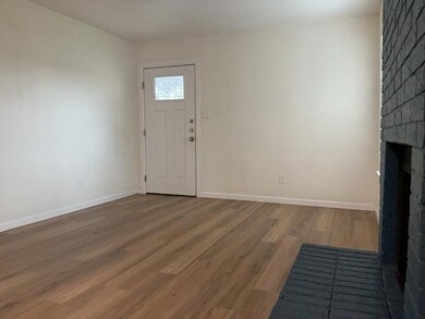 Foyer with wood finished floors and a fireplace