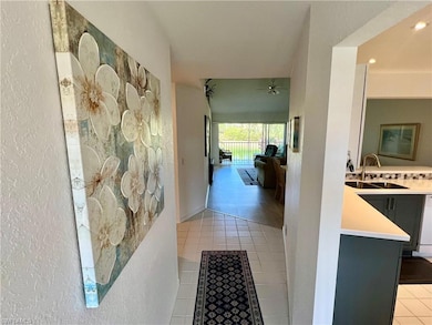 Corridor featuring a sink, a textured wall, and li