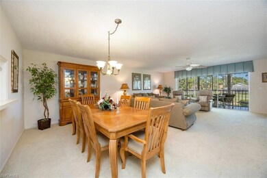 Dining room with baseboards, ceiling fan with notable chandelier, and light carpet