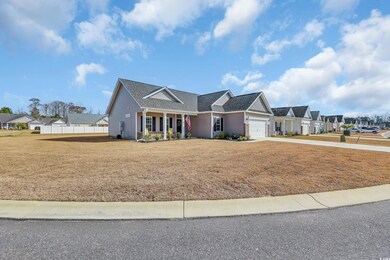 View of front facade featuring driveway, a front lawn, fence, a residential view, and an attached garage