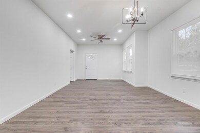 Empty room featuring recessed lighting, wood finished floors, ceiling fan with notable chandelier, and plenty of natural light