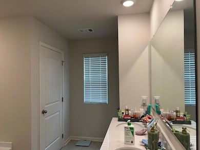 Bathroom featuring double vanity and light tile patterned floors