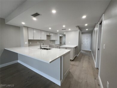 Kitchen featuring visible vents, a sink, wood fini
