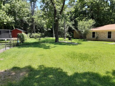 Huge fenced in backyard with beautiful green grass and trees!
