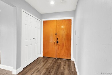 Foyer featuring dark wood-style flooring and baseboards